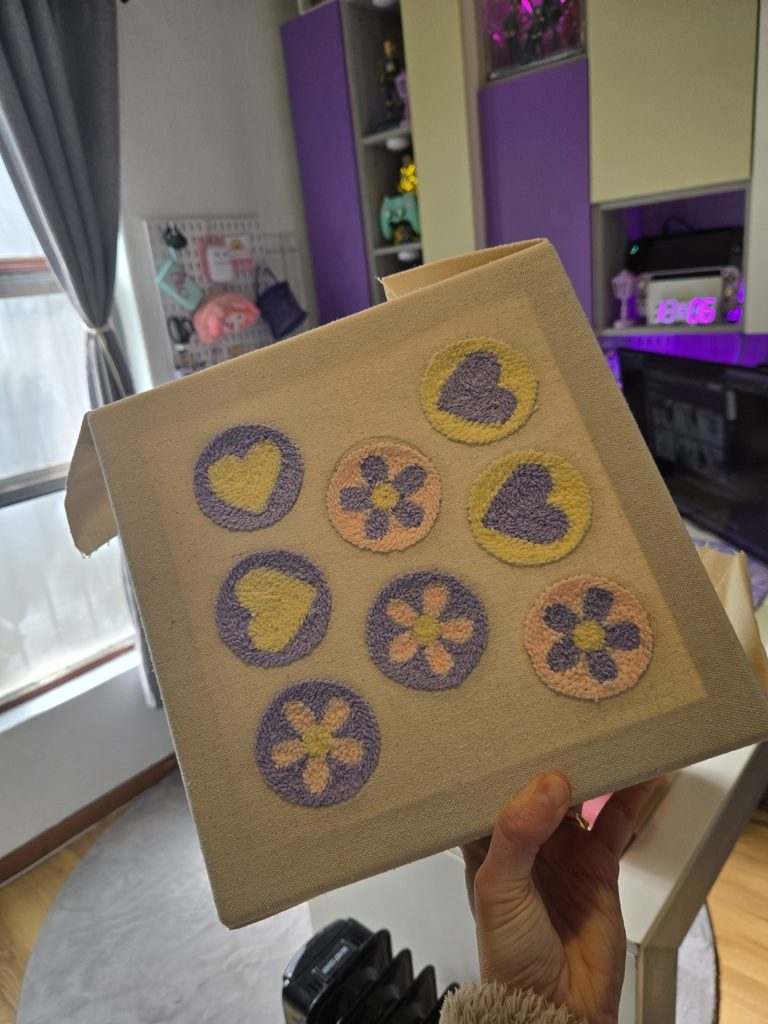 Punch needle heart and flower designs in progress on canvas at the LotsaLoops workspace