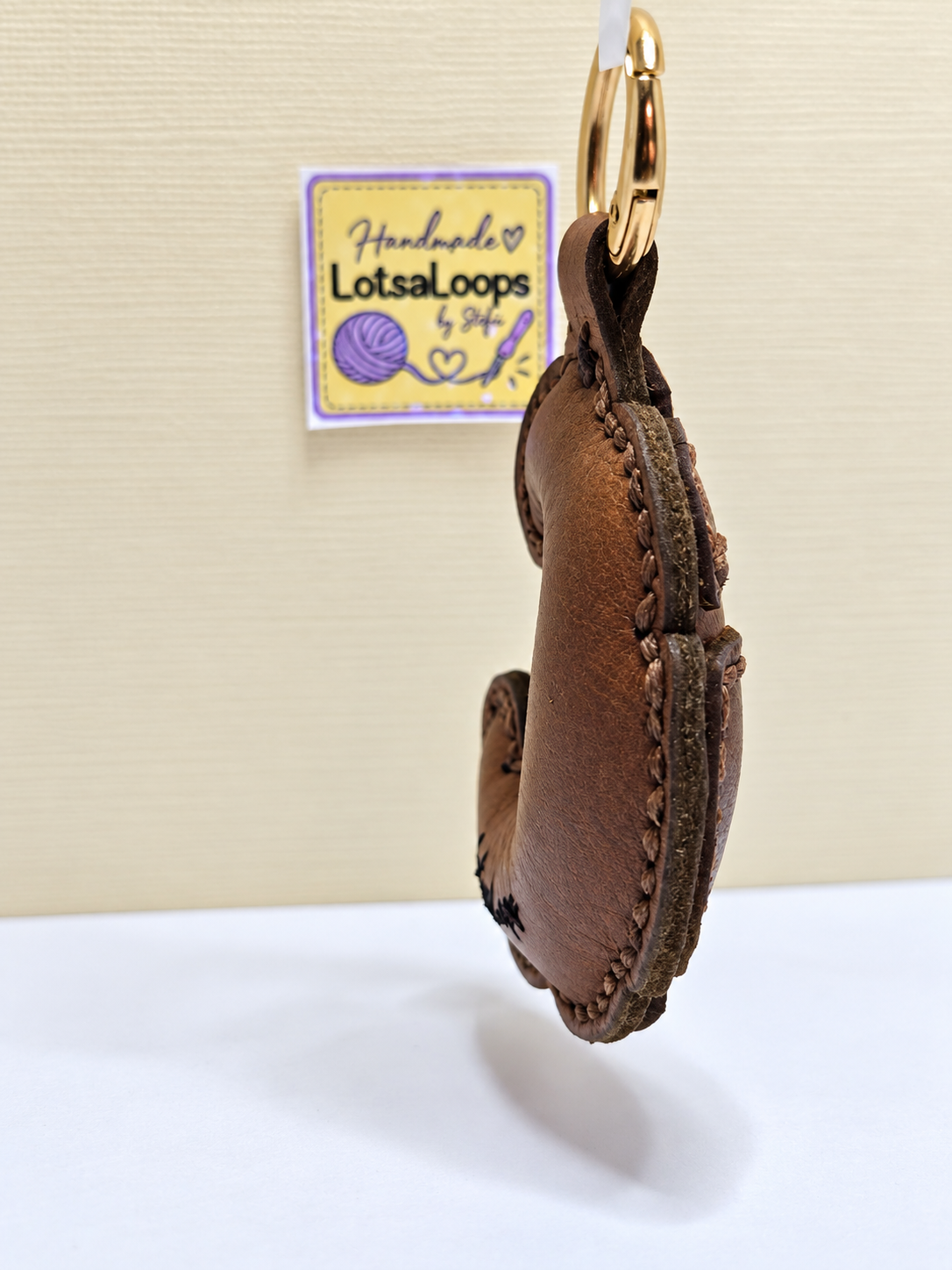 Side view of handmade leather croissant keyring showing layered construction