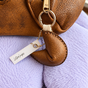 light brown leather fortune cookie keyring and bag charm attached to handbag