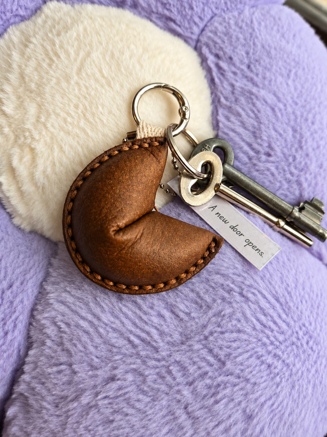 Dark brown leather fortune cookie keyring attached to keys