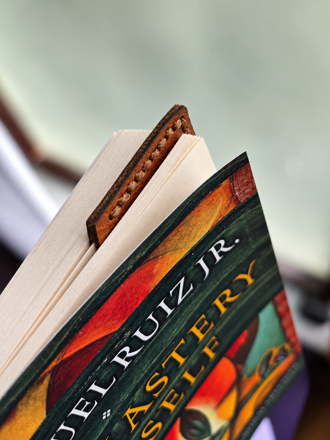 Handmade leather fox corner bookmark tucked between the pages of a book