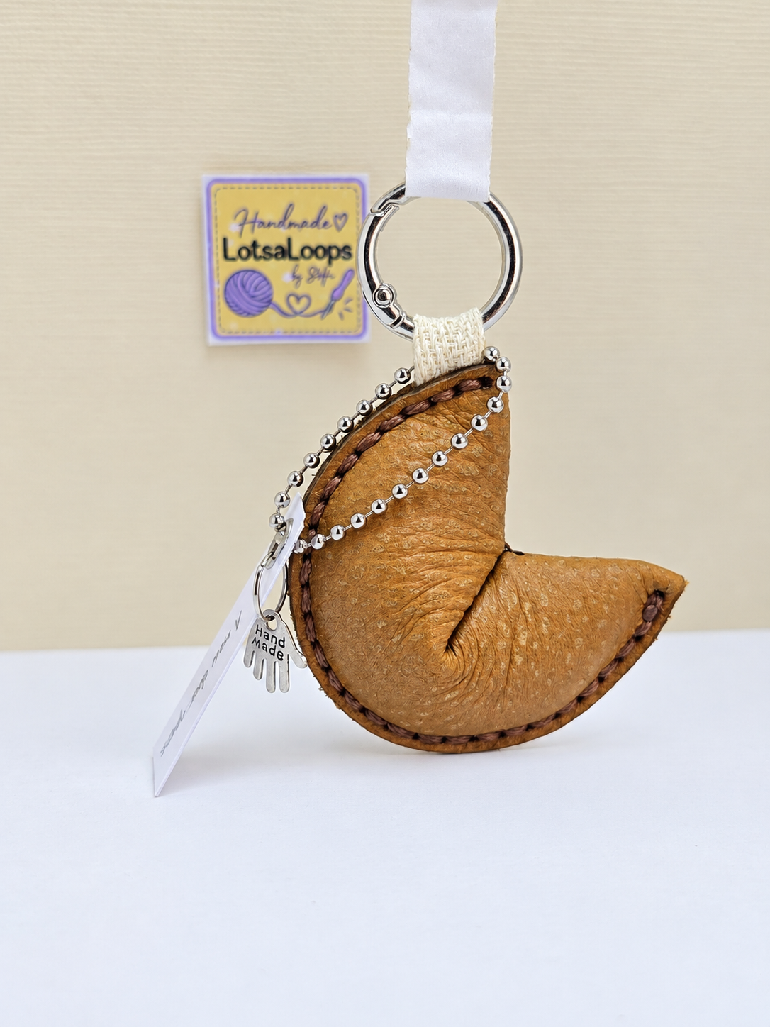 Light brown handmade leather fortune cookie keyring with removable fortune