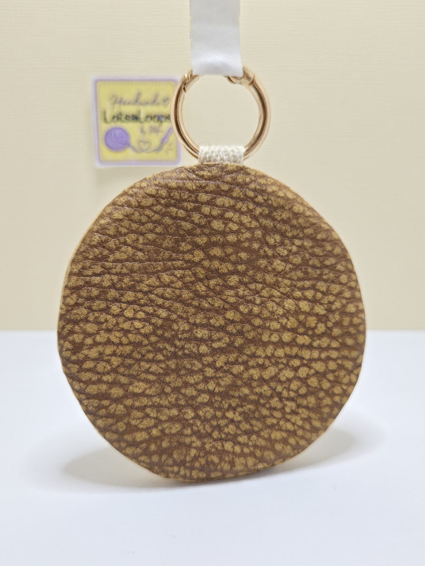 Back view of handmade Snoopy 2-in-1 accessory showing textured brown genuine leather backing and gold clasp.