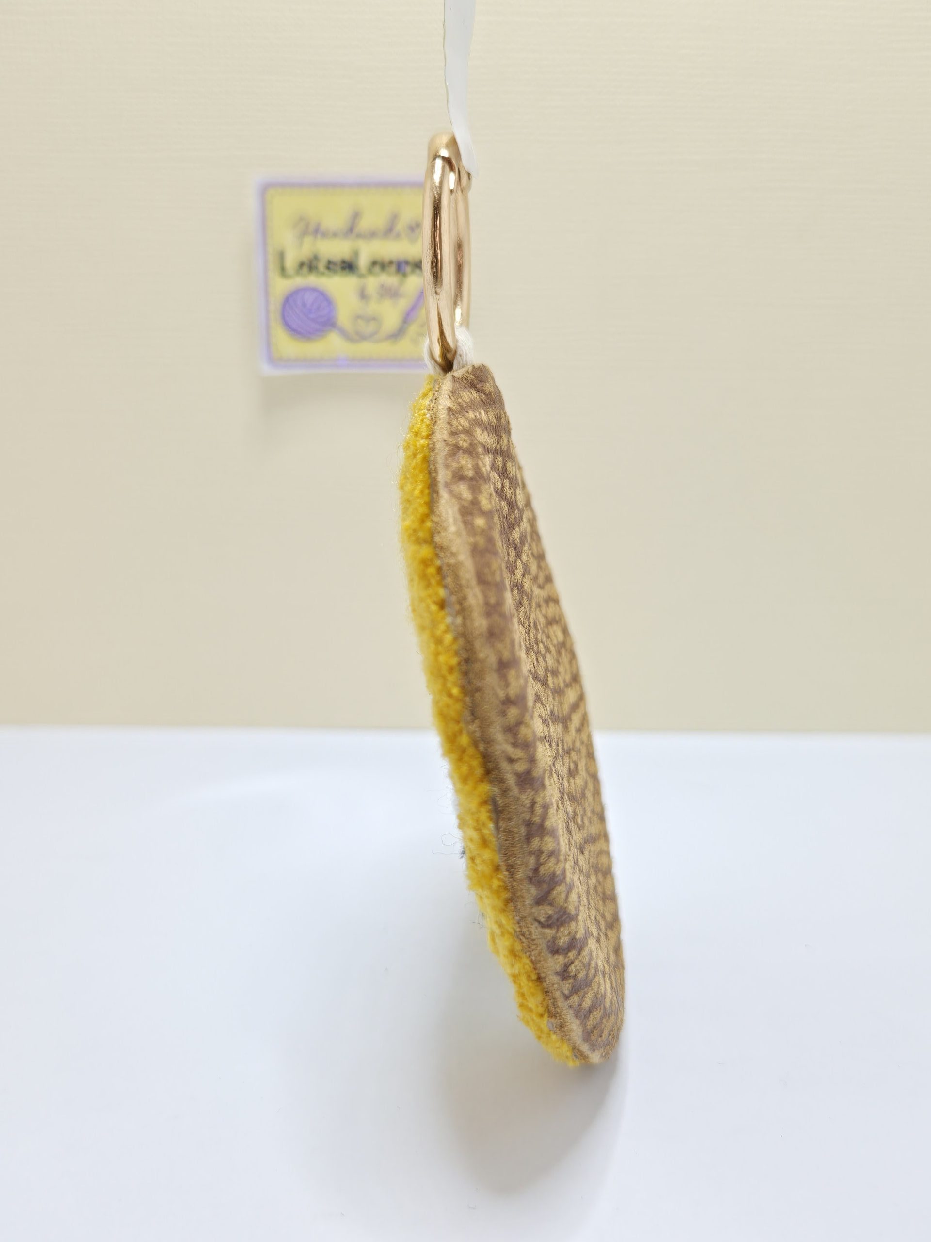 Side view of Snoopy punch needle charm showing the thickness of the yarn loops and genuine leather backing.